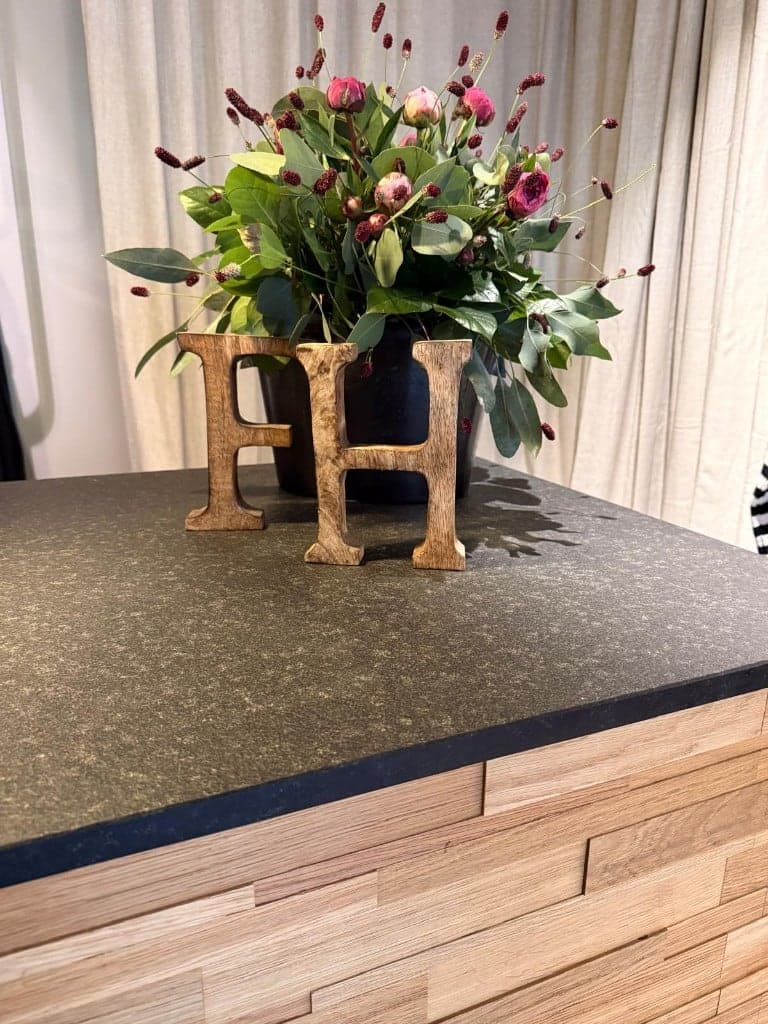 Feine Heimat Holzbuchstaben und frische Blumen auf der Eichentheke